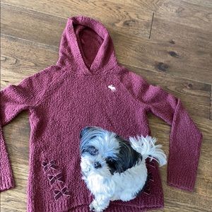 A knitted maroon sweater hooded